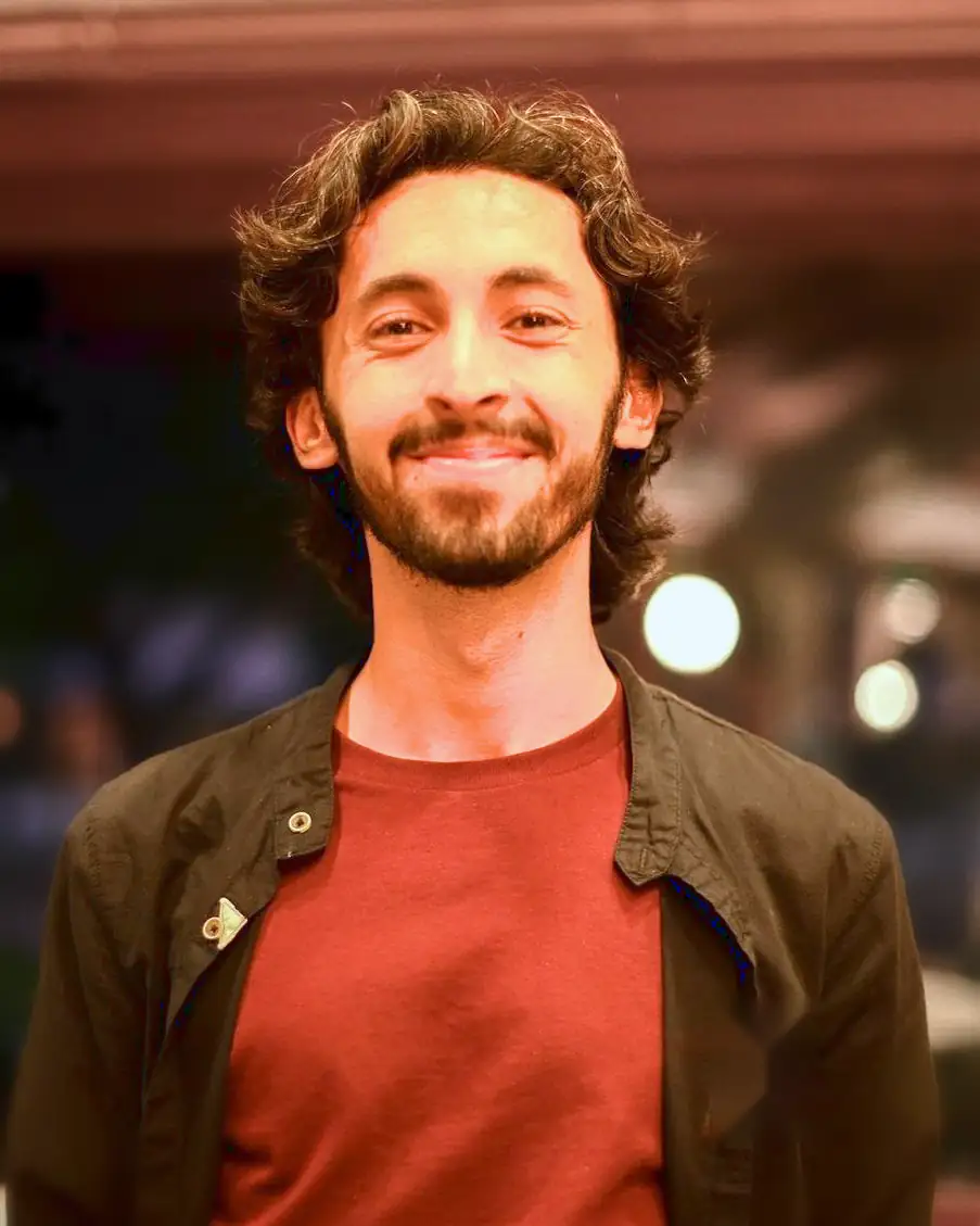 Mohammed Bukhari, smiling, at a team event in the evening.